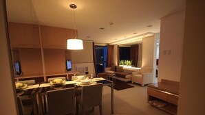 Een moderne hotelkamer met een eethoek, een zithoek en uitzicht op de stad.