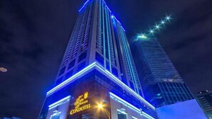 Een hoog gebouw met verlichte reclame voor Grand Windsor Condotel.