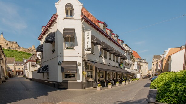 A white building with a red-tiled roof and a sign that reads "HOTEL". - Hulsman (Valkenburg aan de Geul)