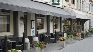 A hotel with outdoor seating and planters. - Hulsman (Valkenburg aan de Geul)