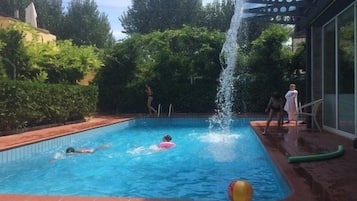 Una piscina al aire libre de temporada, sillones reclinables de piscina