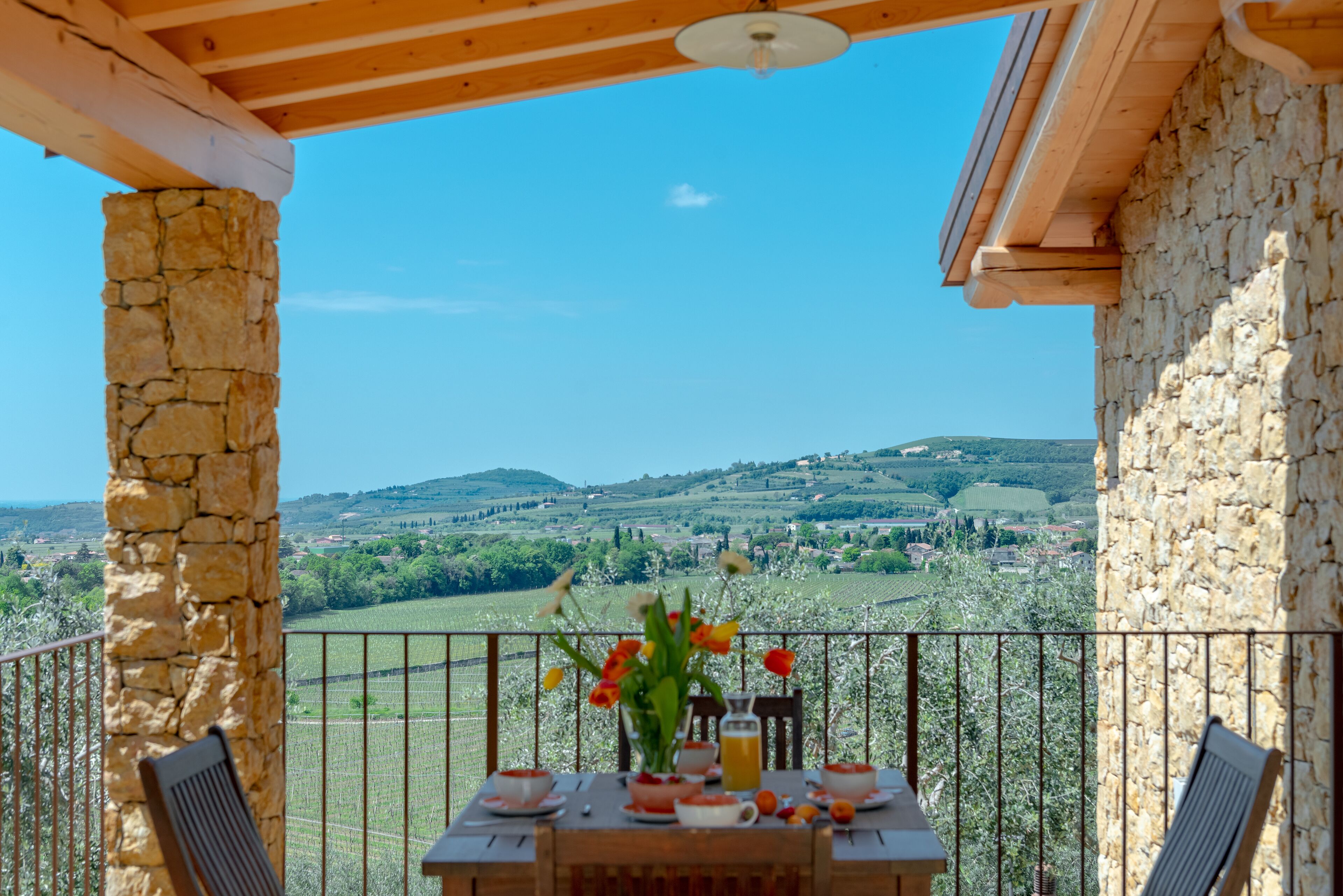Ein Balkon mit Frühstückstisch, mit Blick auf eine schöne Landschaft.