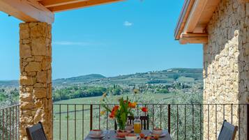 Ein Balkon mit Frühstückstisch, mit Blick auf eine schöne Landschaft.