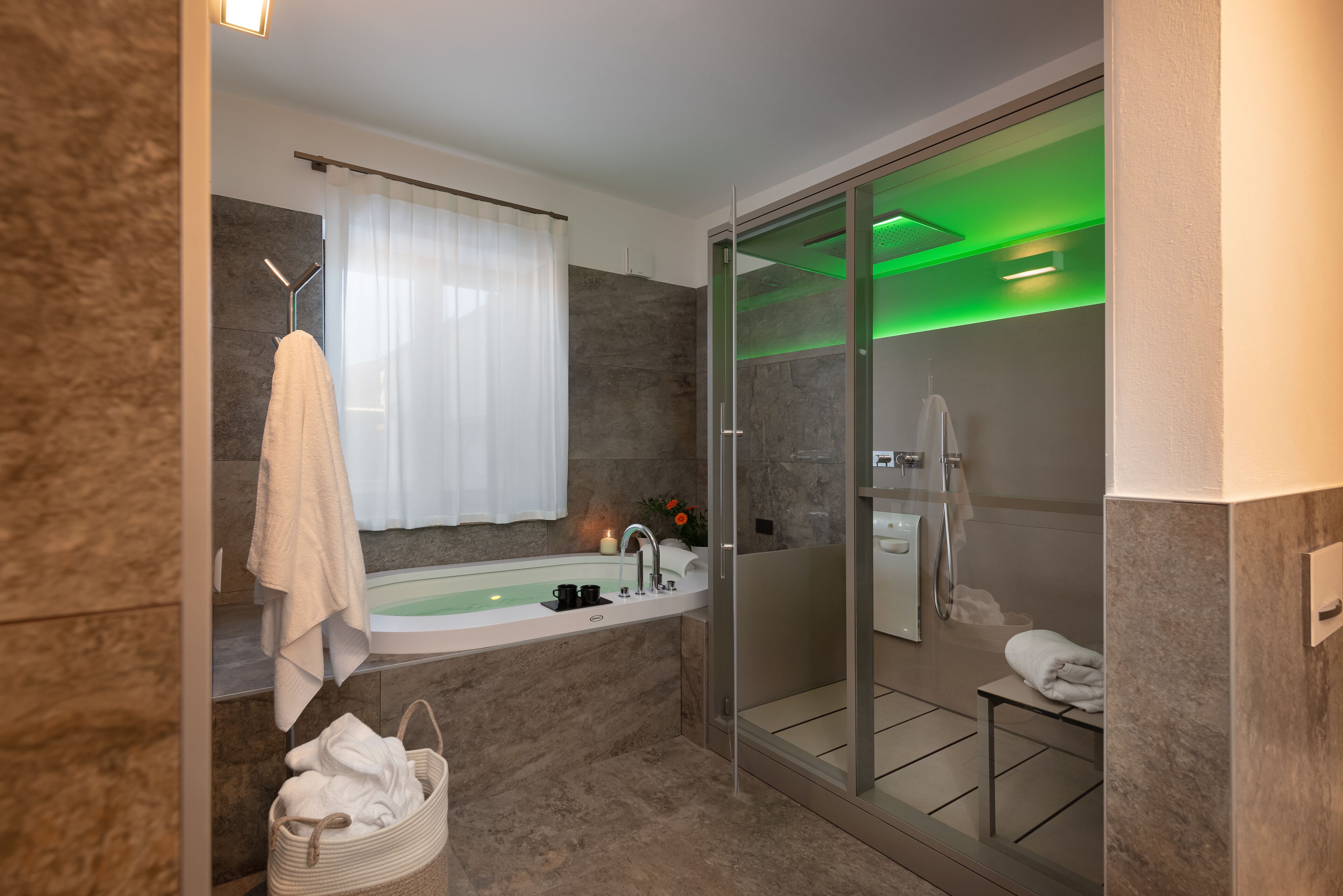 Ein modernes Badezimmer mit Badewanne, Dusche und einer Glaskabine.