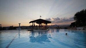 En swimmingpool med ett lusthus och solstolar.