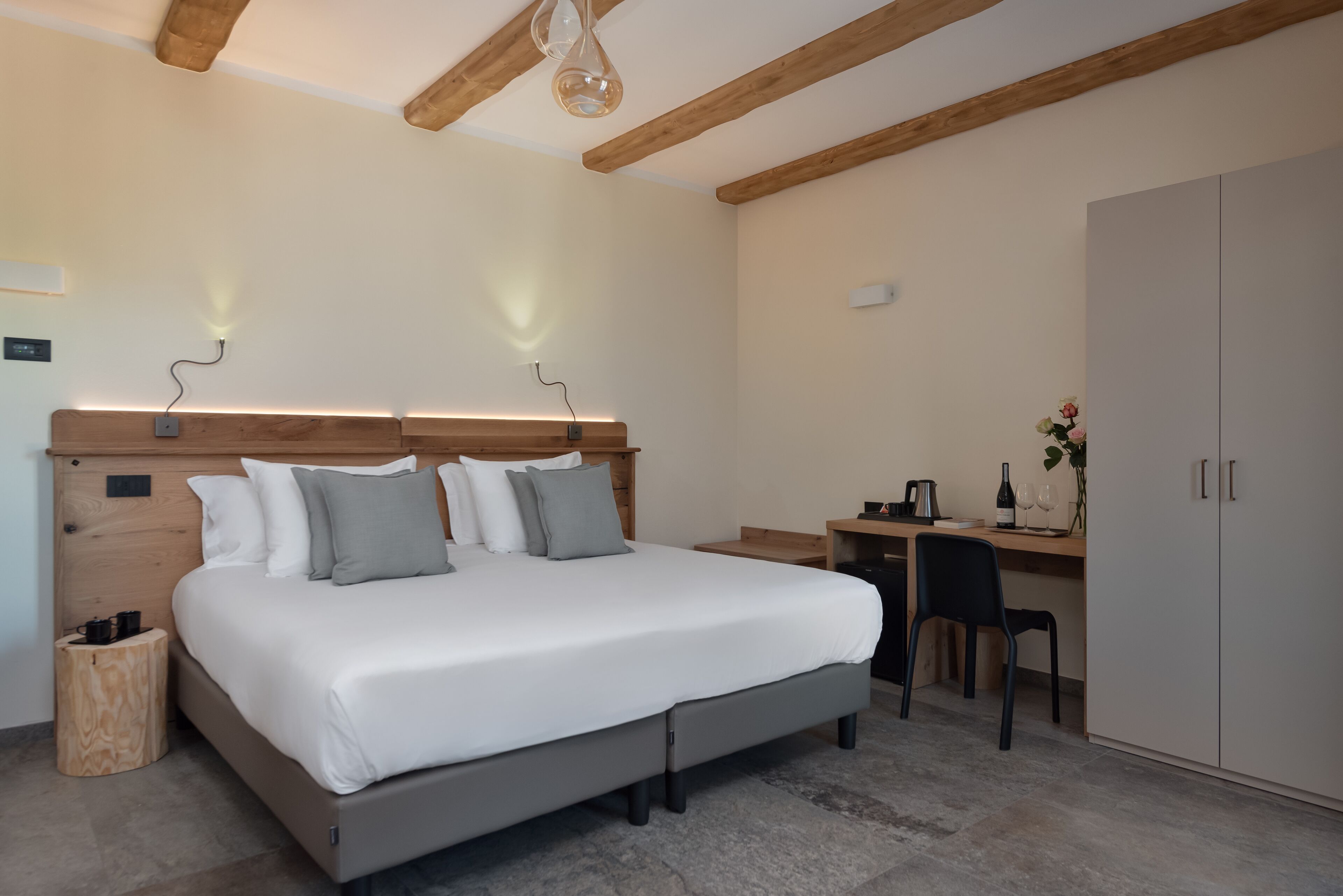 Une chambre à coucher avec un grand lit, des tables de chevet, un bureau avec une chaise et une armoire.