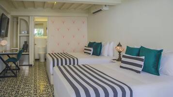 A hotel room with two beds, a desk, and a chair.