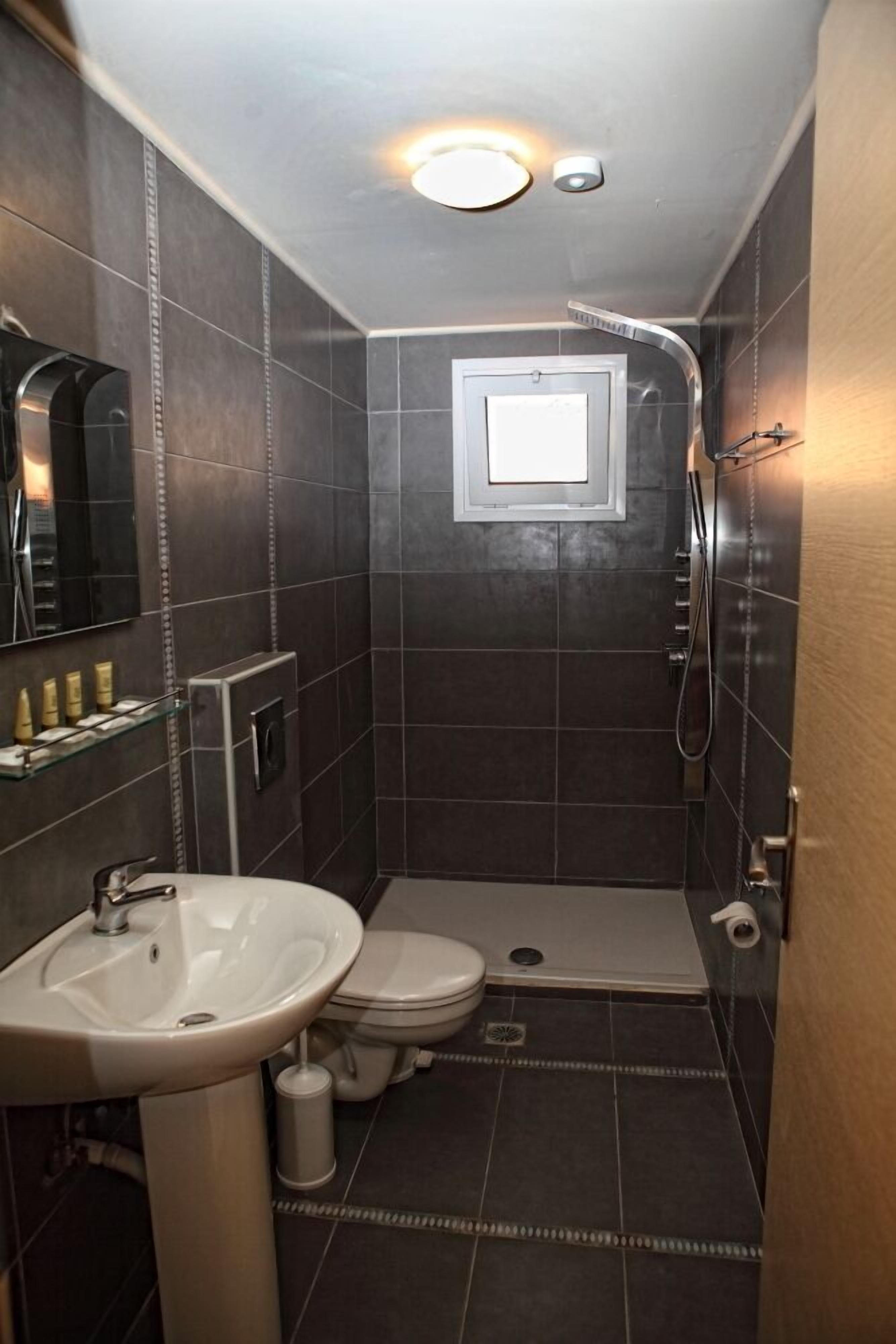 Un baño pequeño con lavamanos, inodoro y ducha.