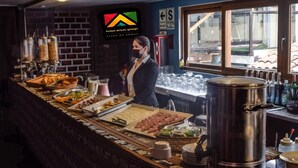 Mesa de buffet con diferentes opciones de comida y una olla grande en la encimera.