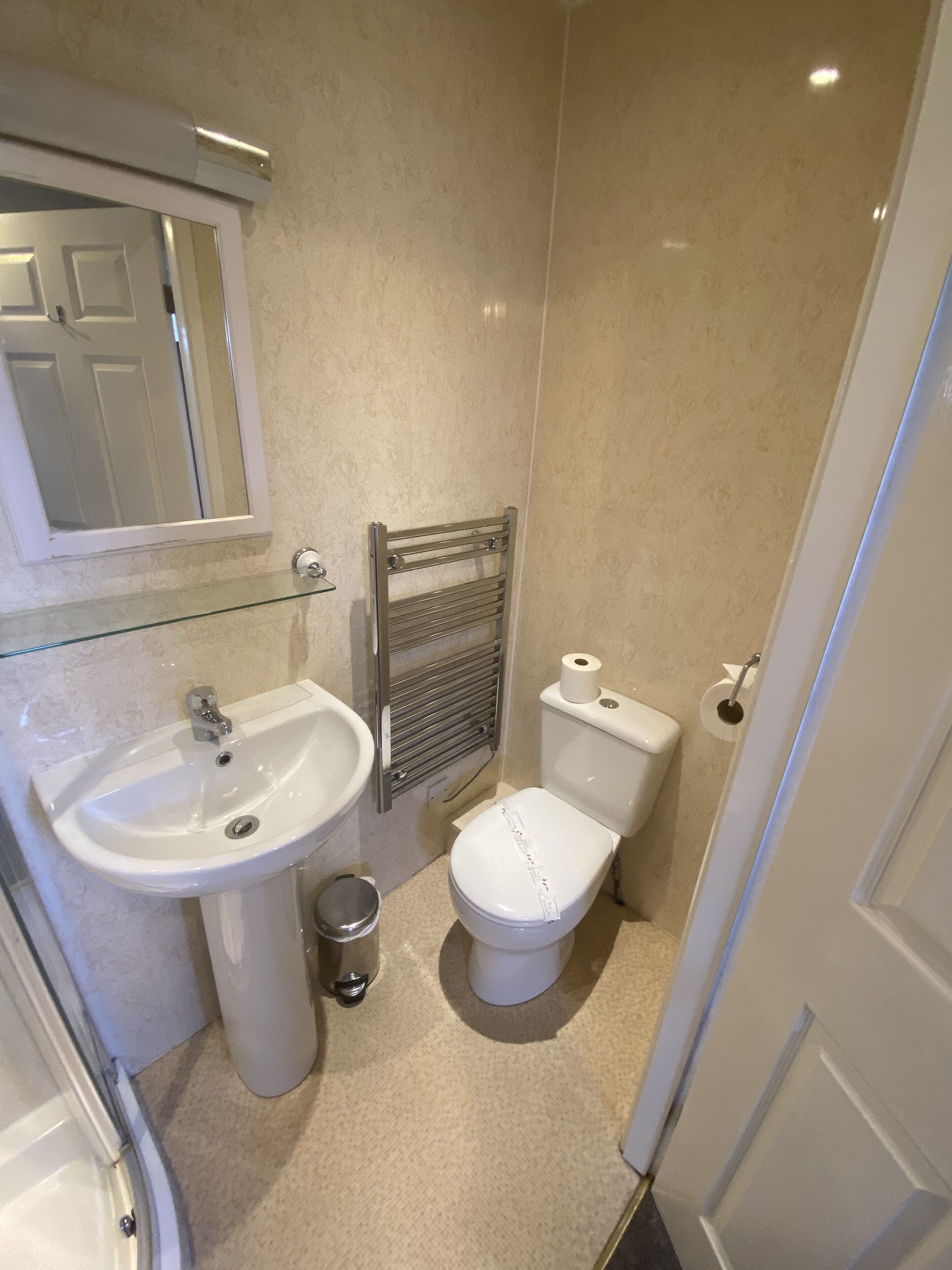 Ein kleines Badezimmer mit Waschbecken, Toilette und Handtuchhalter.