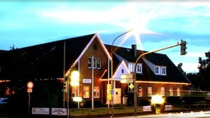 Een hotel in traditionele bouwstijl, herkenbaar aan het opvallende puntgeveldak en een bord met de vermelding 'hotel'.