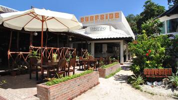 Et resort med udendørs siddepladser, et skilt med 'Sureside Boracay Resort & Spa' og en sti til indgangen.
