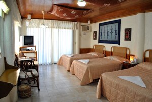Una habitación de hotel con dos camas, un escritorio con televisor y un comedor.