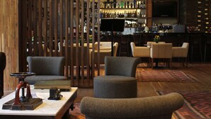 Ein moderner Lounge-Bereich mit Sitzgelegenheiten, einer Bar und einem Bücherregal.