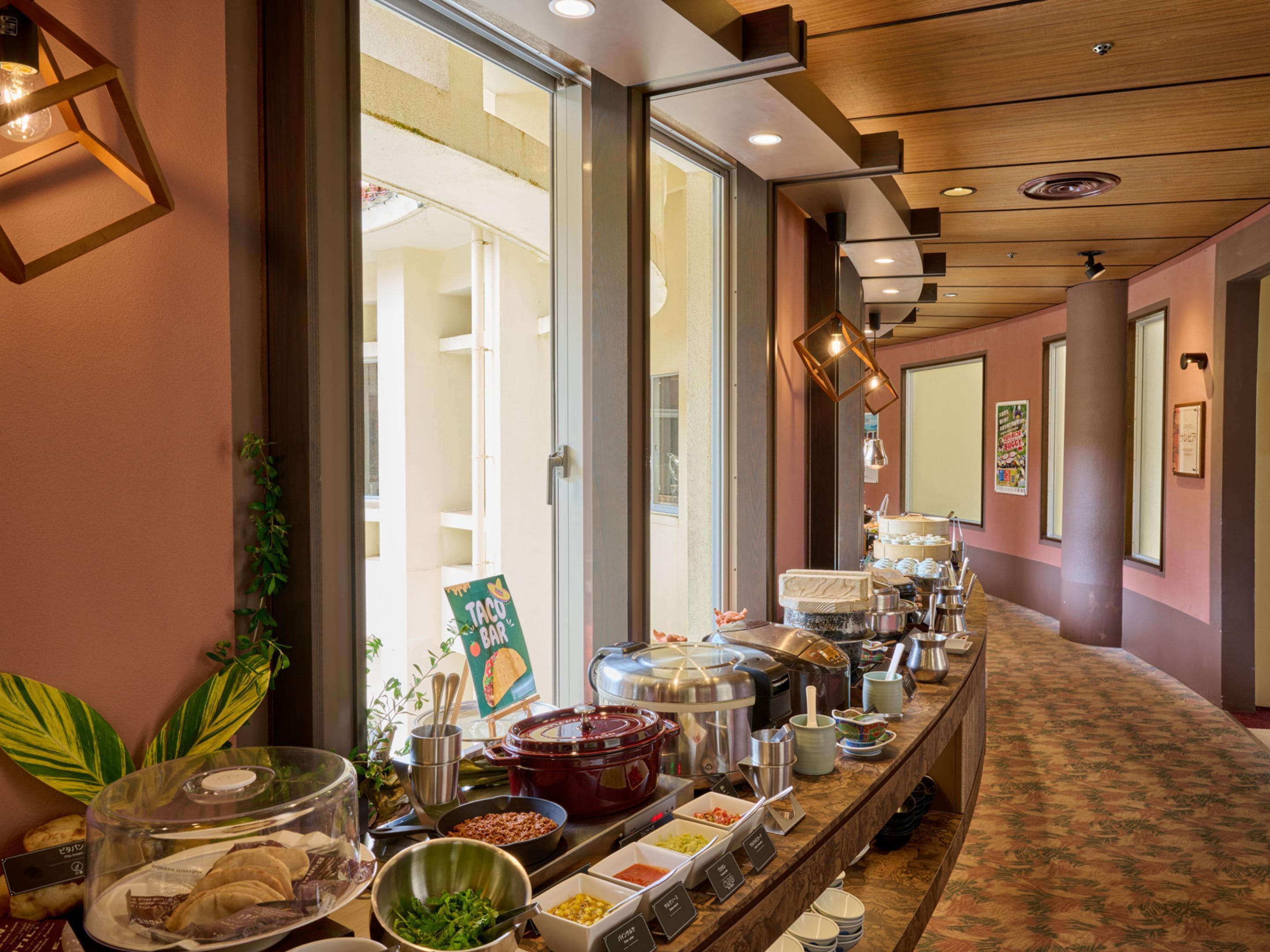 A buffet setup with various food containers and a sign indicating a taco bar.