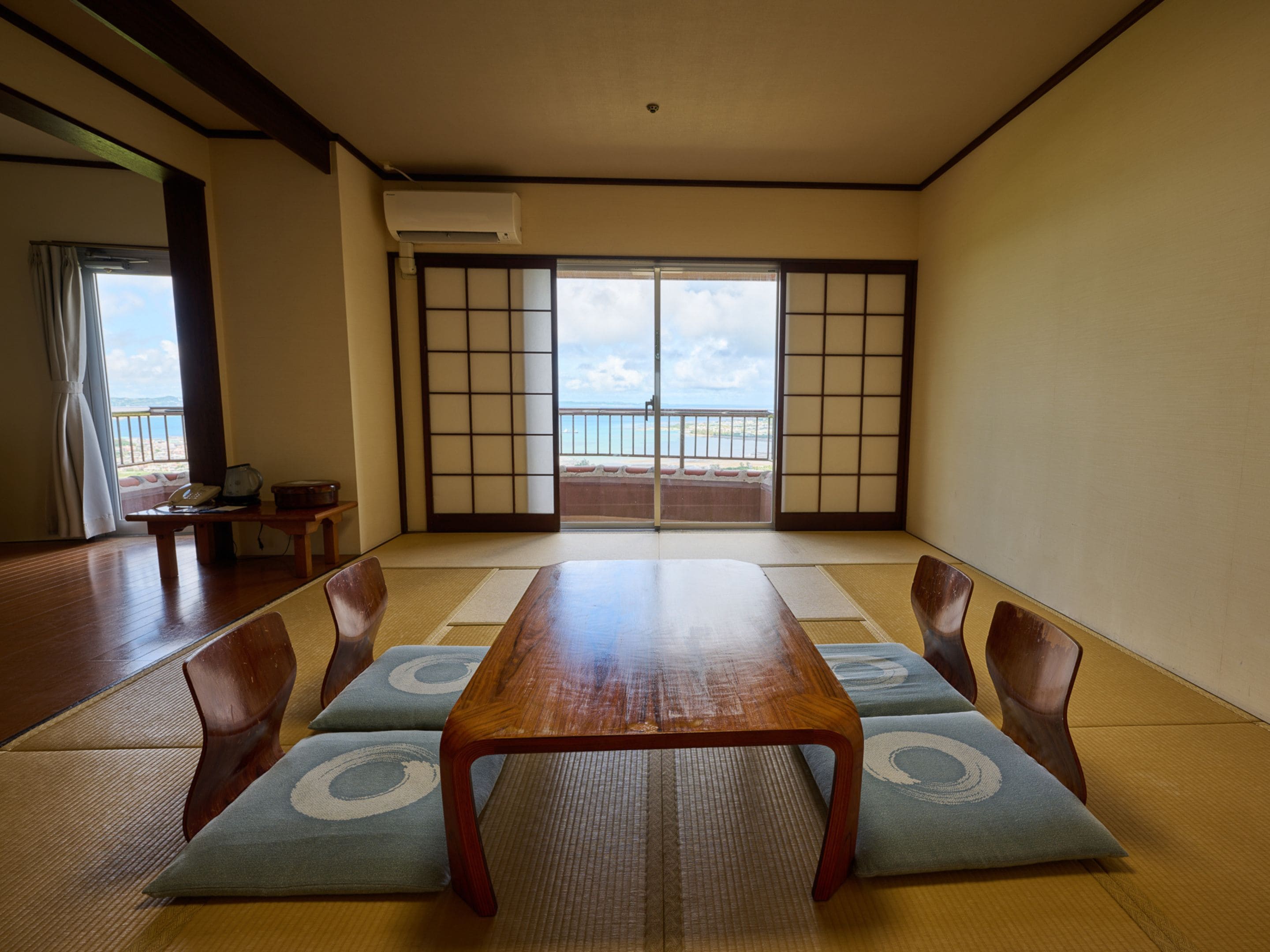 A traditional Japanese room with tatami flooring, a low wooden table, and shoji screens.