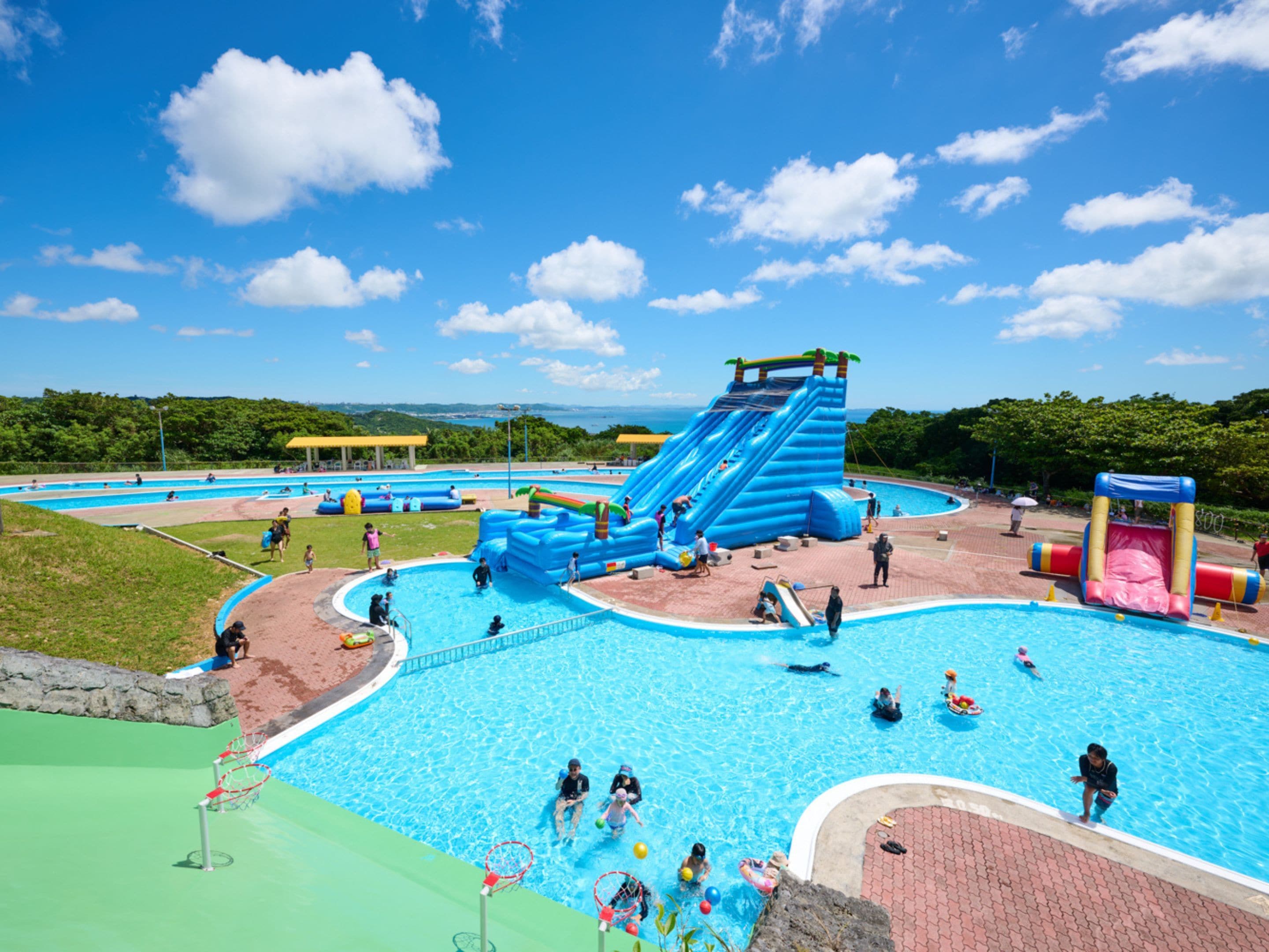 Un parc aquatique doté de plusieurs piscines, de toboggans et de structures de jeux gonflables.
