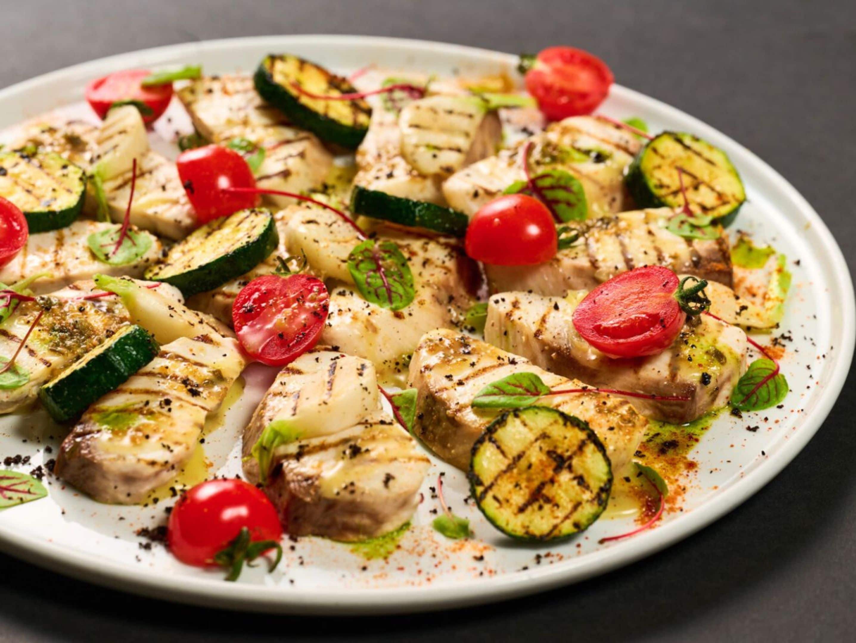 A plate of grilled chicken and vegetables.