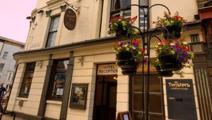 A hotel reception with a sign for 'Hotel Reception' and 'Twisters' bar & lounge.