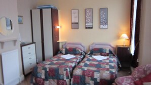 A room with two beds, a wardrobe, a desk, and a chair. - Sussex Hotel (Blackpool)