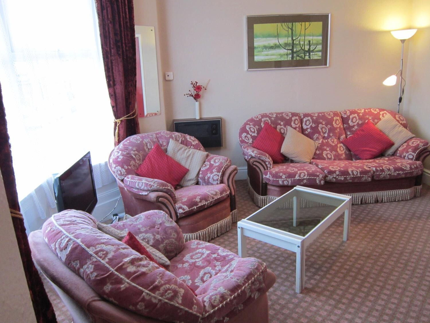 A living room with a sofa set, a coffee table, and a painting on the wall.