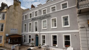 A building with a sign reading "Alexandra" and a café bar sign below it. - Alexandra Hotel (Weymouth)