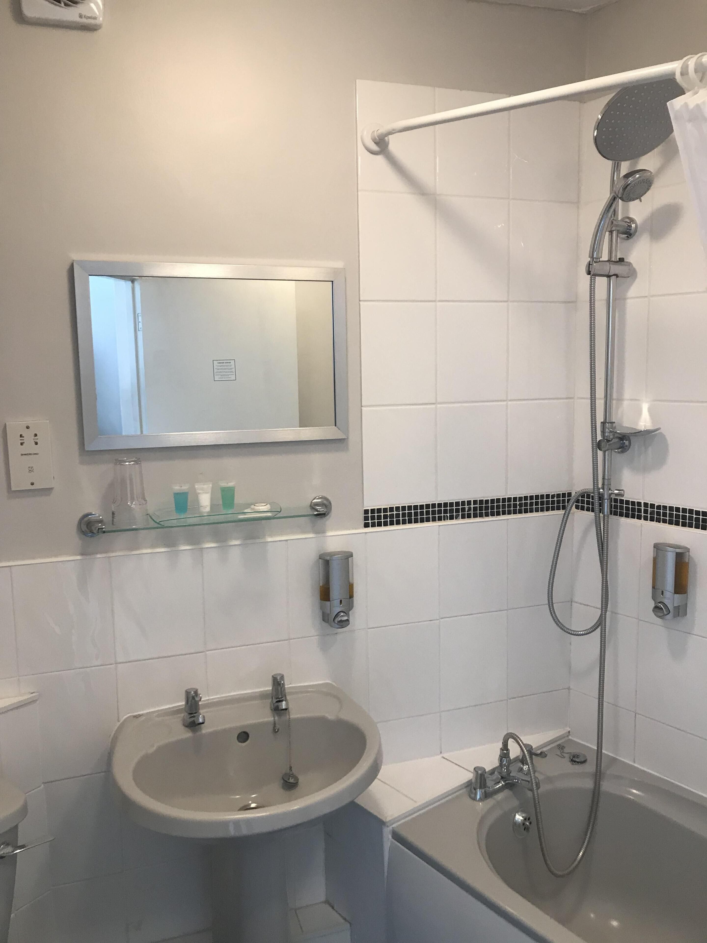 Un baño con lavamanos, inodoro y bañera.