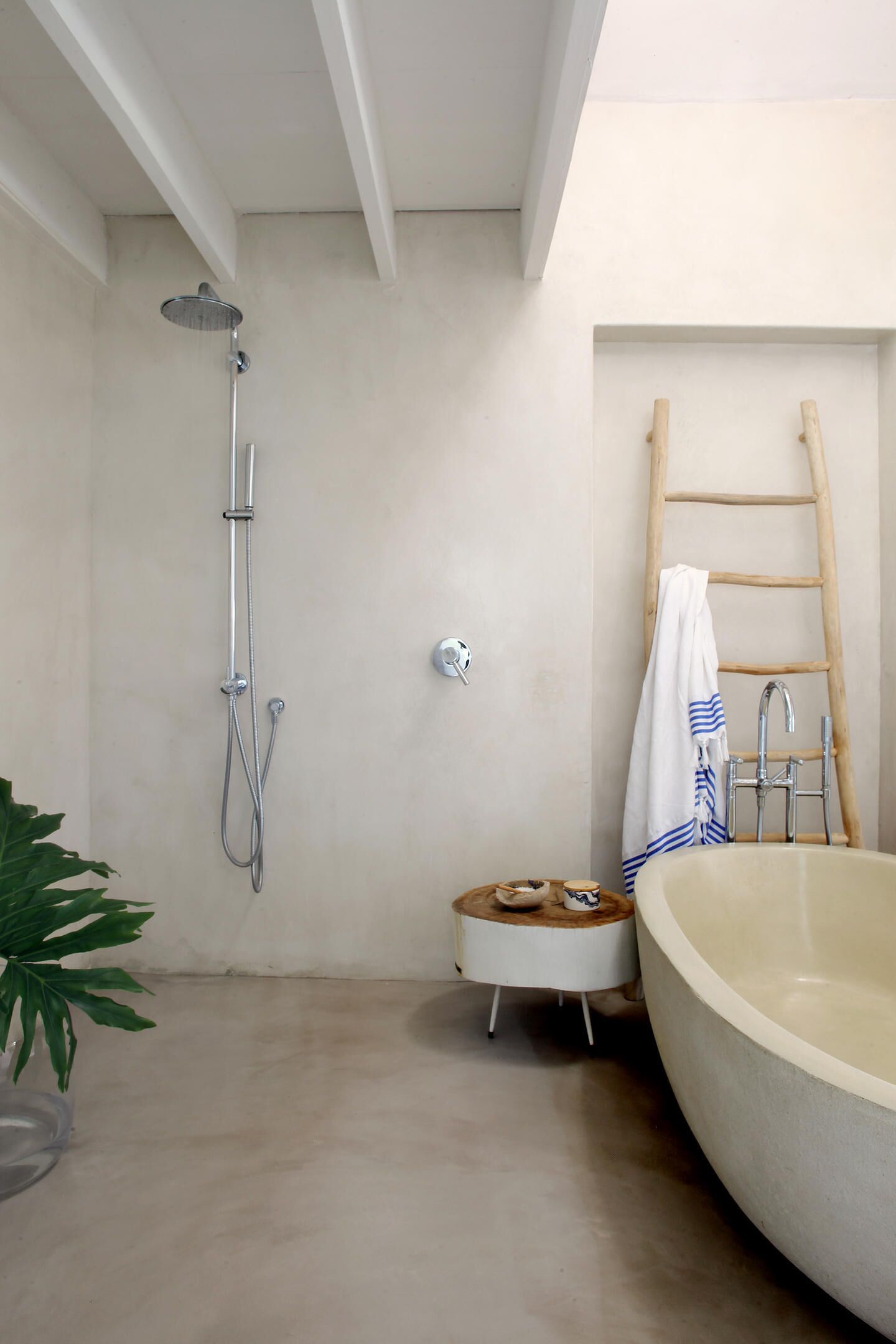 A bathroom with a shower, a bathtub, a small stool, and a towel rack.