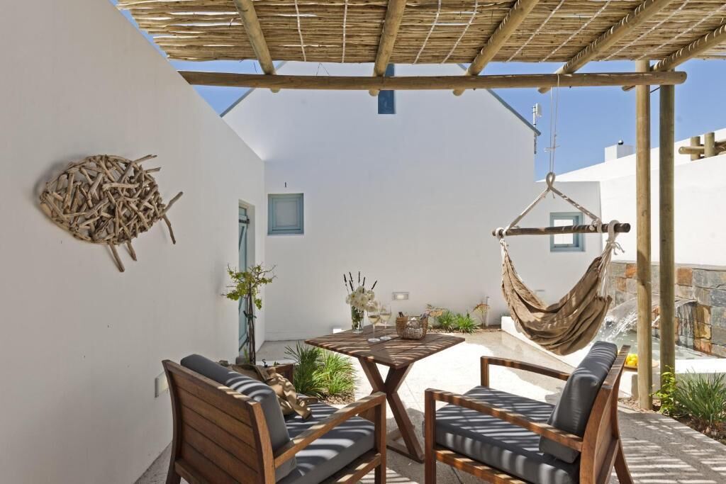 A patio with wooden furniture, a hanging hammock, and a wall-mounted decorative piece.
