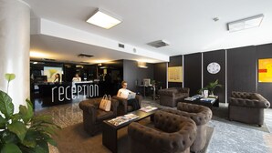 Un área de recepción con mostrador, asientos y un reloj en la pared.