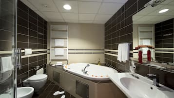 Ein modernes Badezimmer mit einer großen Badewanne, separatem Waschbecken und WC.