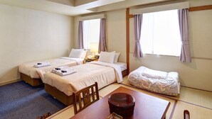 A hotel room with two beds, a small table, a chair, a bedside table with a lamp, and a window with curtains. - Okinawa Sunplaza Hotel (Naha)