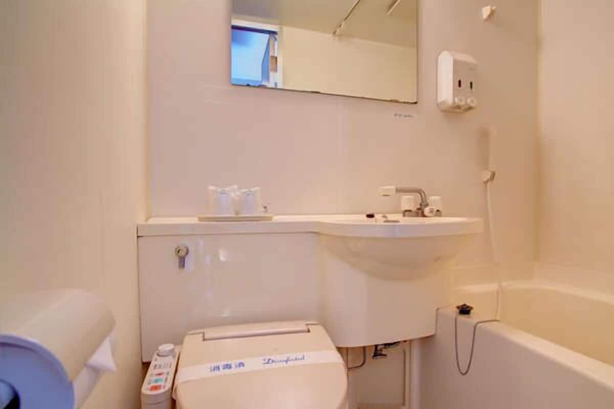 A small, clean bathroom with a toilet, sink, and bathtub.
