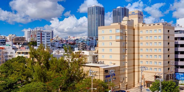 A multi-story hotel with a flat roof, surrounded by other buildings and trees. - Okinawa Sunplaza Hotel (Naha)