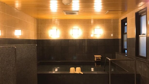 A public restroom with a black sink, two white basins, and a hand dryer. - Smile Hotel Namba (Osaka)