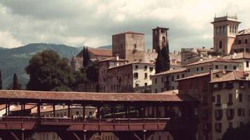 Un pueblo histórico con arquitectura medieval, que incluye una torre destacada y un puente.