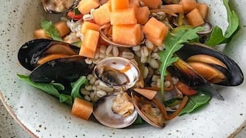 Ensalada de mariscos con mejillones, zanahorias y verduras de hoja.