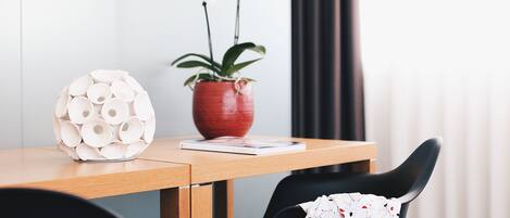 A wooden table with a white spherical object and a red vase with white flowers.