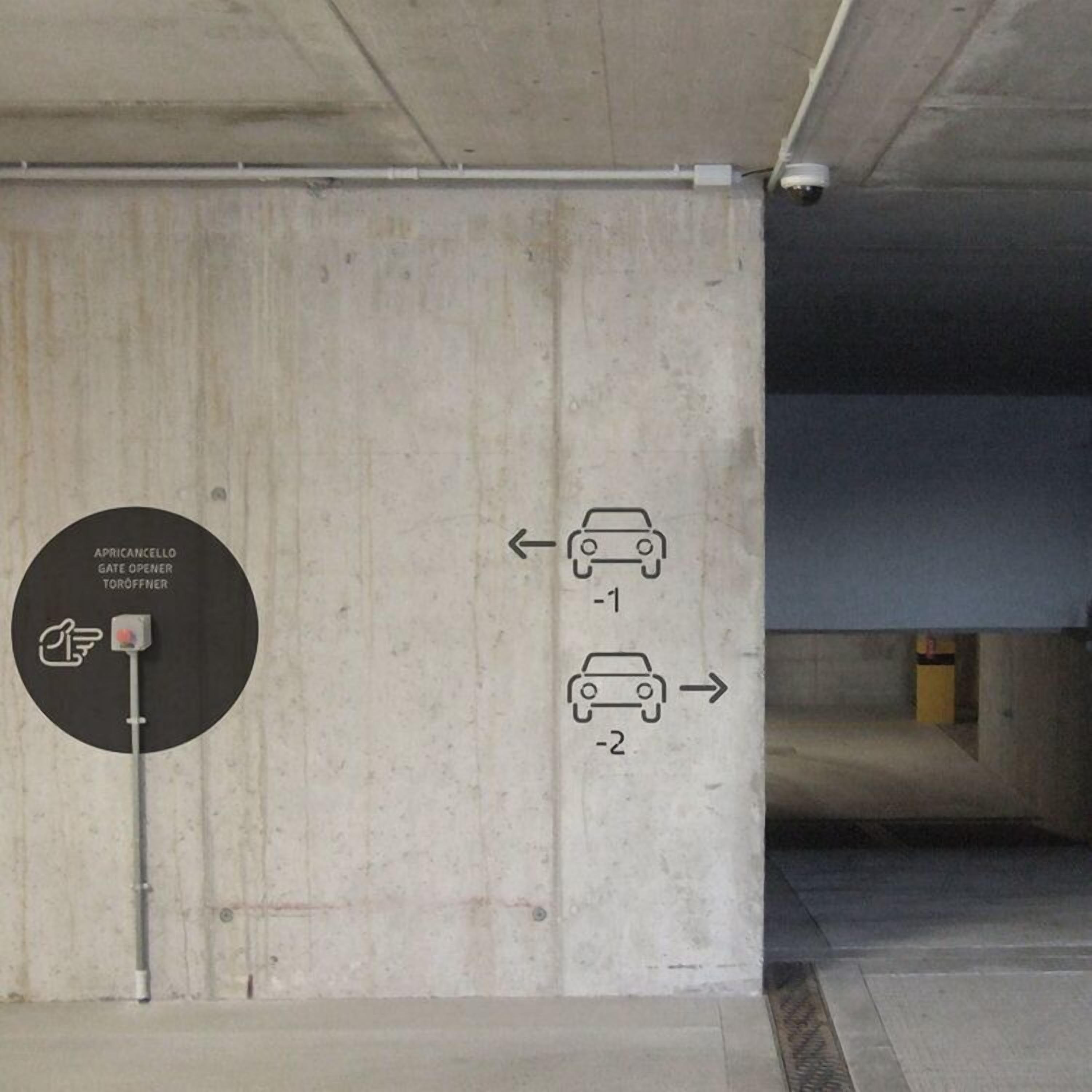 A parking garage with directional signs for parking spaces -1 and -2.