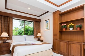 Relax in a serene space with a large bed, bedside tables, and a wooden cabinet above, perfect for unwinding.