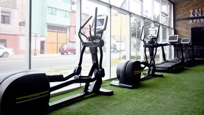 Una palestra con attrezzature sportive e ampie vetrate.