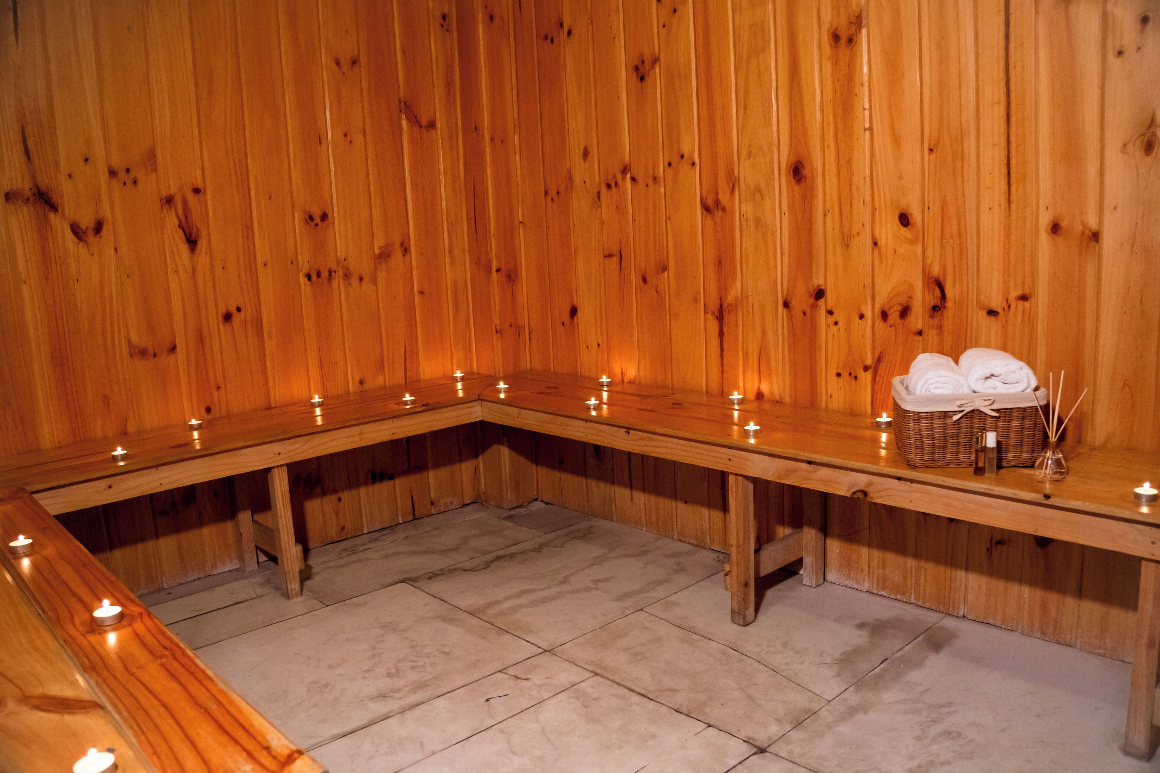 Un sauna en bois avec des bancs et des bougies.