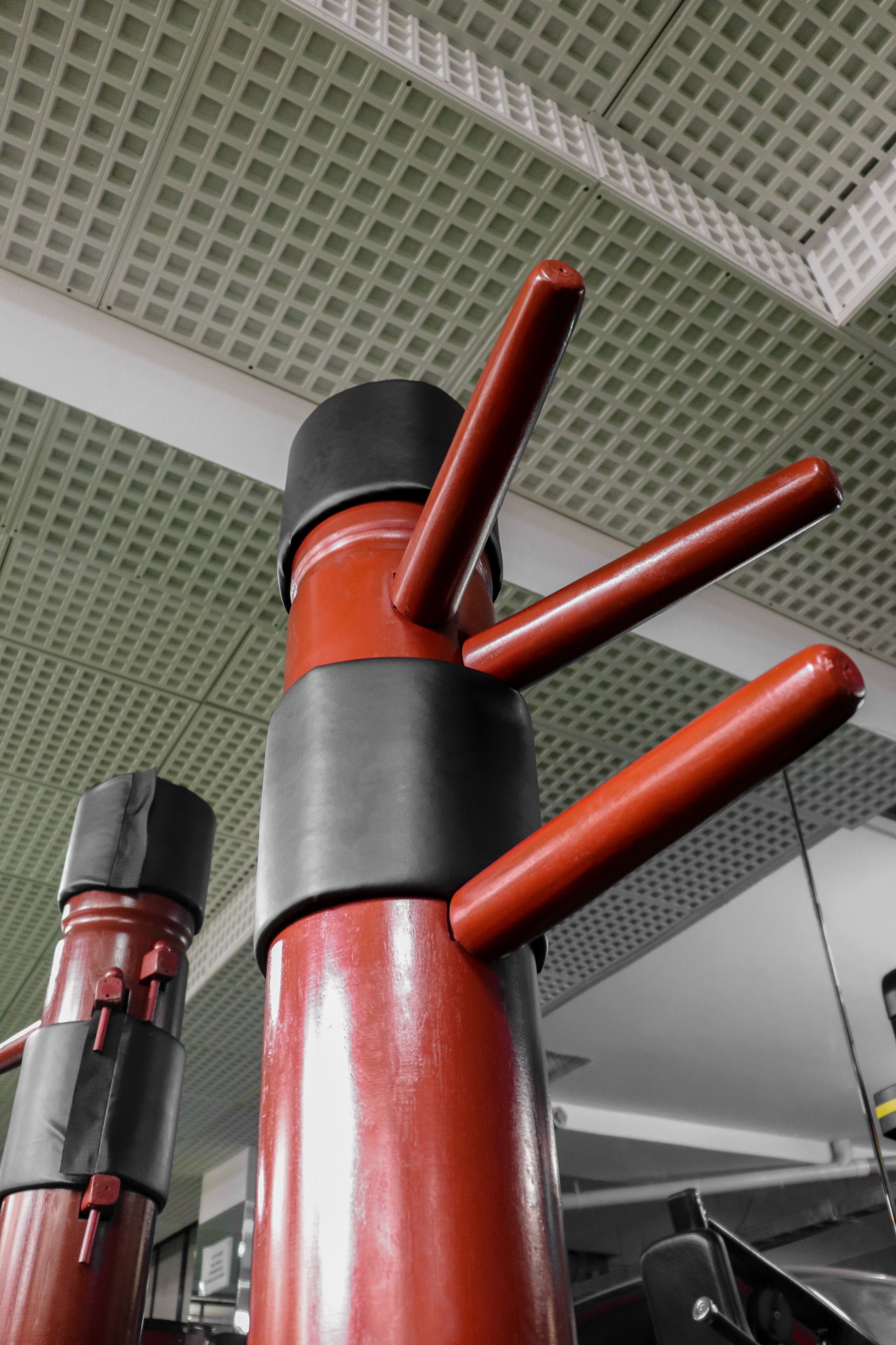 Un dispensador de agua de estilo industrial en rojo y negro, con un techo de diseño de cuadrícula al fondo.