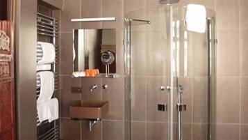 A modern bathroom with a glass shower enclosure, a built-in sink, and a mirror.