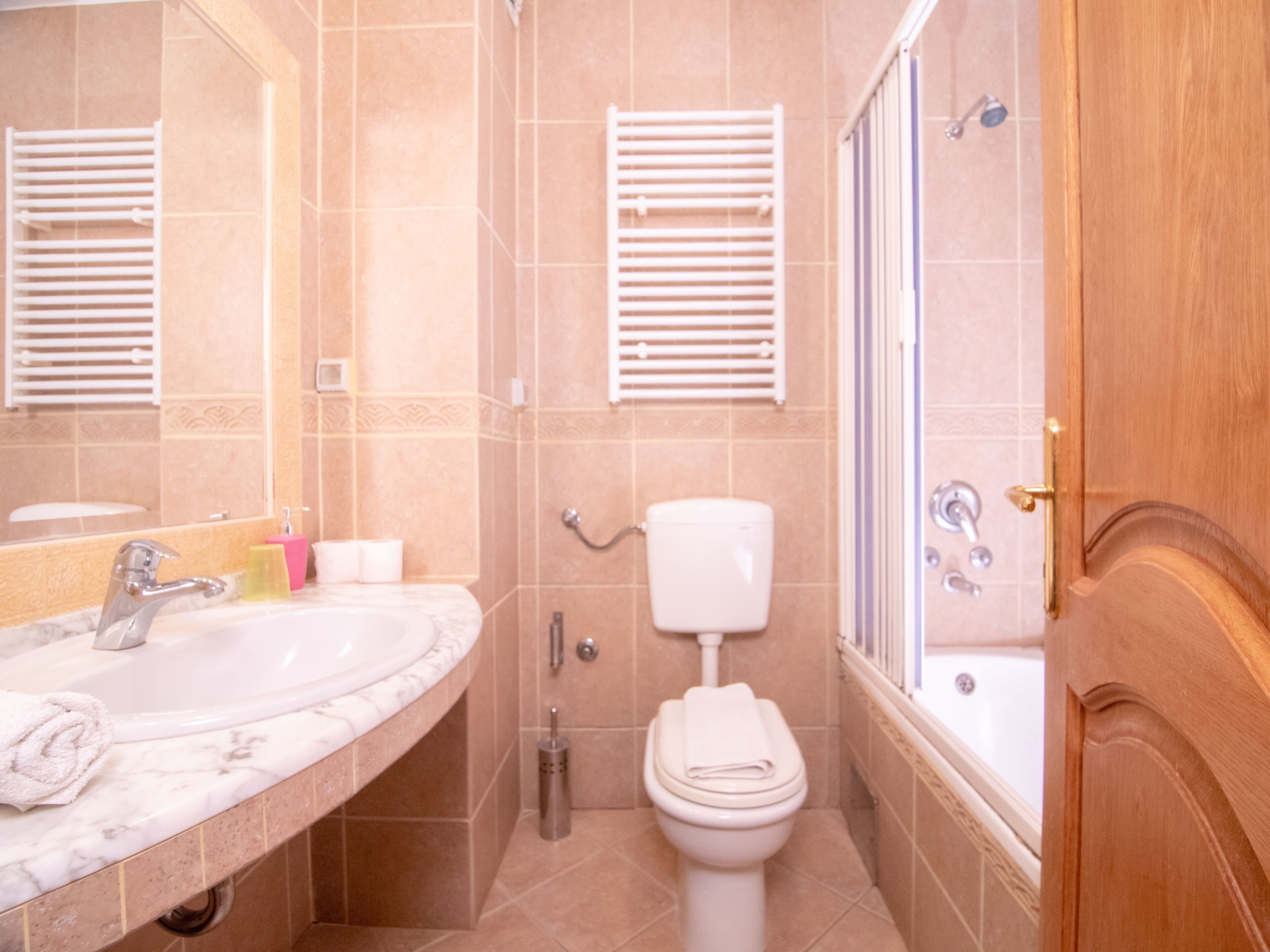 Un baño con lavamanos, inodoro y ducha de mármol.