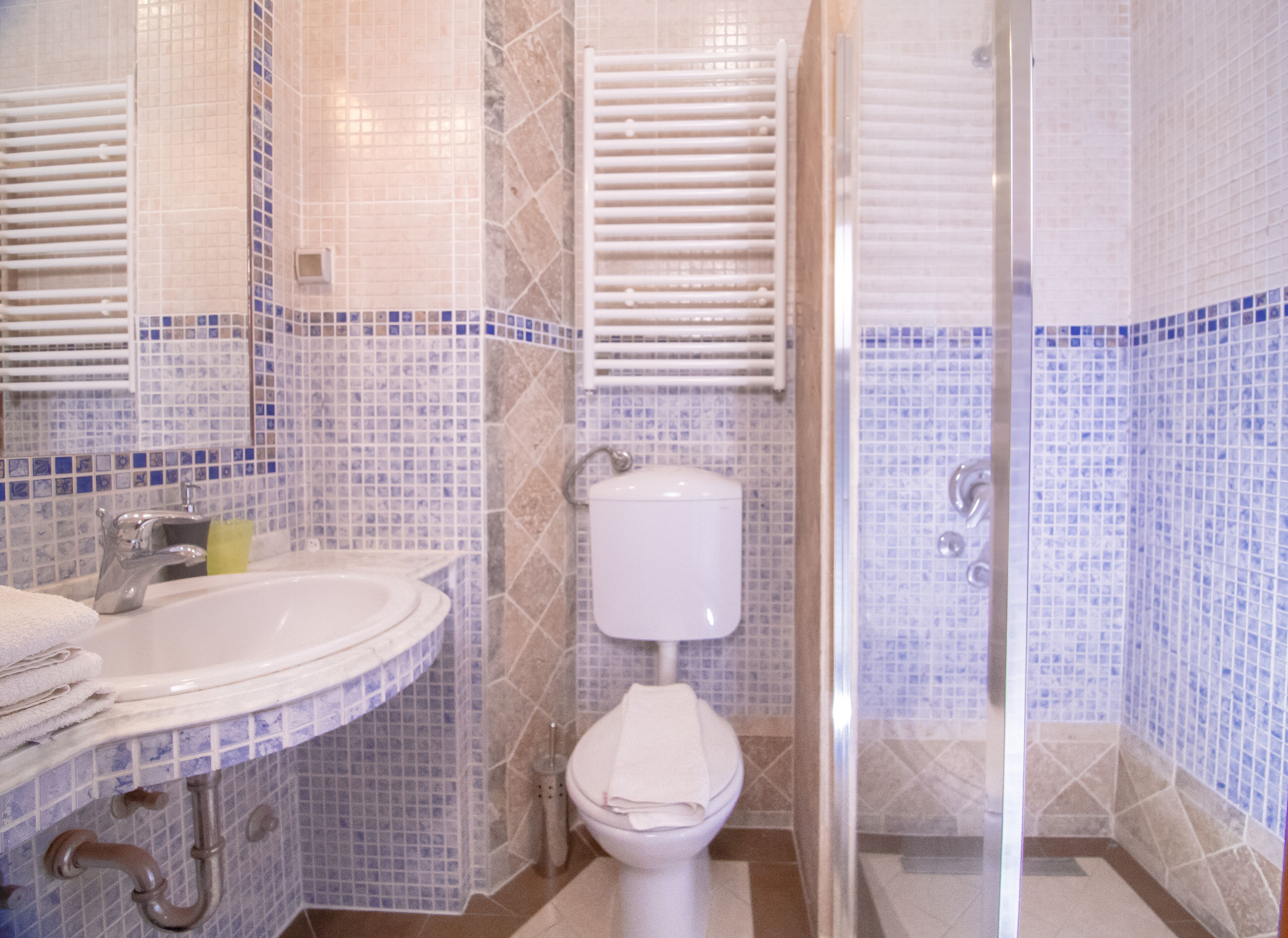 A bathroom with a sink, toilet, and shower area.