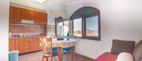 Un espacio habitable compacto con comedor, cocina y una zona de estar acogedora.