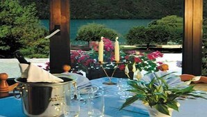 A table set for dining with a view of a lake and hills. - Hotel Florida (Levico Terme)