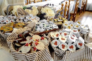 A table set with various food items, including jars, bottles, and plates with food labels. - Hotel Florida (Levico Terme)