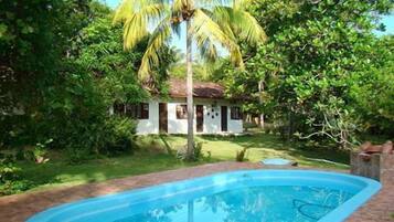 Una piscina al aire libre, sillones reclinables de piscina